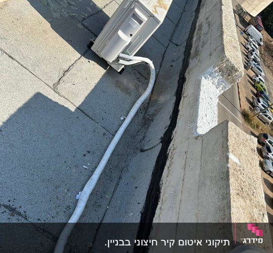 איטום גג עם חומר שחור ליד מזגן